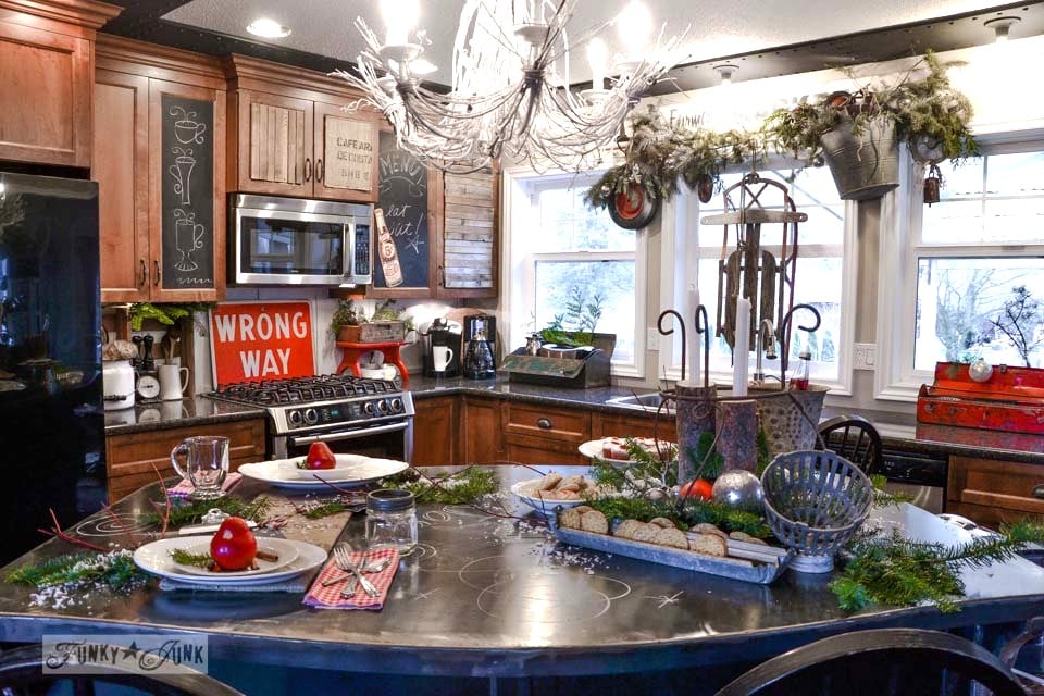 Black metal kitchen island decked out with Christmas food / A junky Christmas kitchen / salvaged finds used to deck out this kitchen for Christmas via https://www.funkyjunkinteriors.net/ Black metal kitchen island decked out with Christmas food / A junky Christmas kitchen / salvaged finds used to deck out this kitchen for Christmas via https://www.funkyjunkinteriors.net/