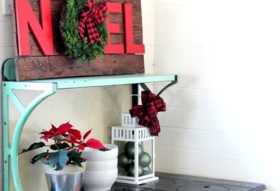 Rustic-Christmas-pallet-noel-wreath-sign-on-antique-stove-with-ornaments-in-lantern-Knick-of-Time