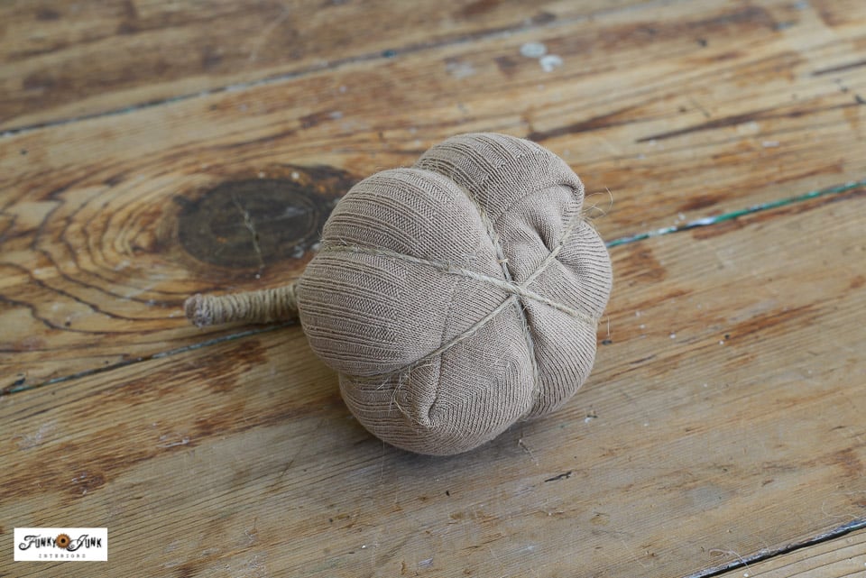 twine crossing on the bottom of a sock pumpkin