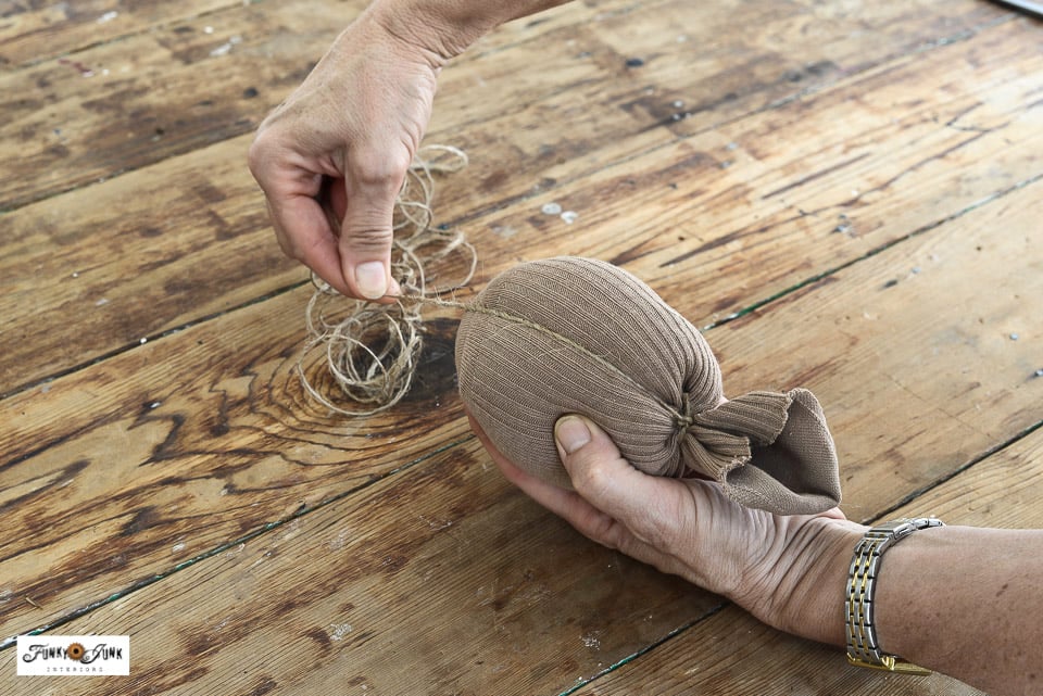wrapping a stuffed sock to create a pumpkin
