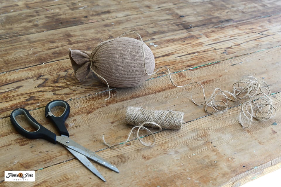 wrapping twine around a sock to form a fabric pumpkin