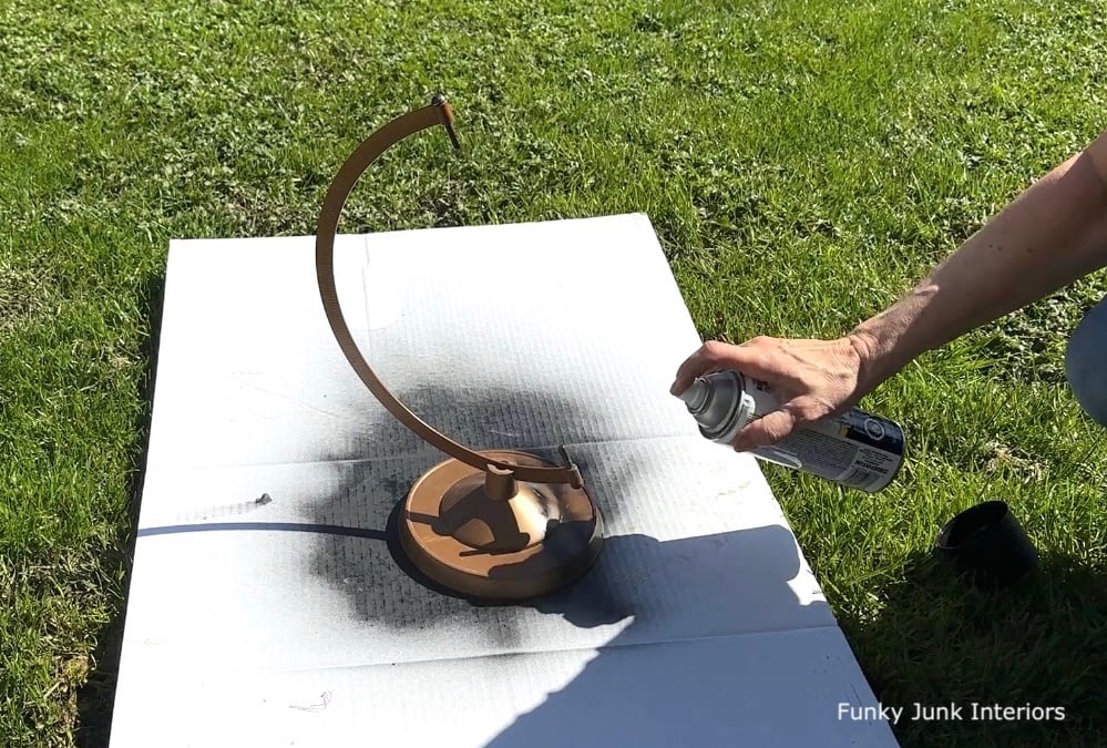 spray painting an upcycled globe stand black