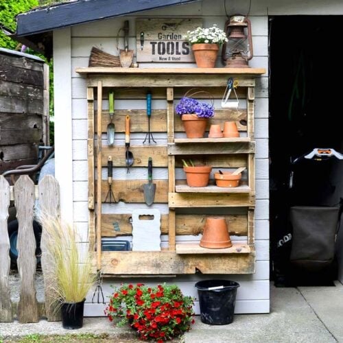 DIY pallet yard tool organizer with shelves and hooks