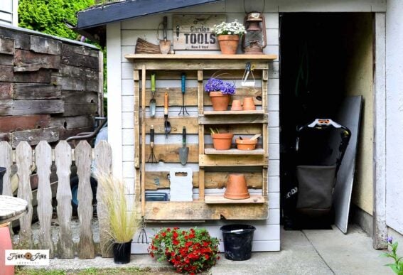 DIY pallet yard tool organizer with shelves and hooks