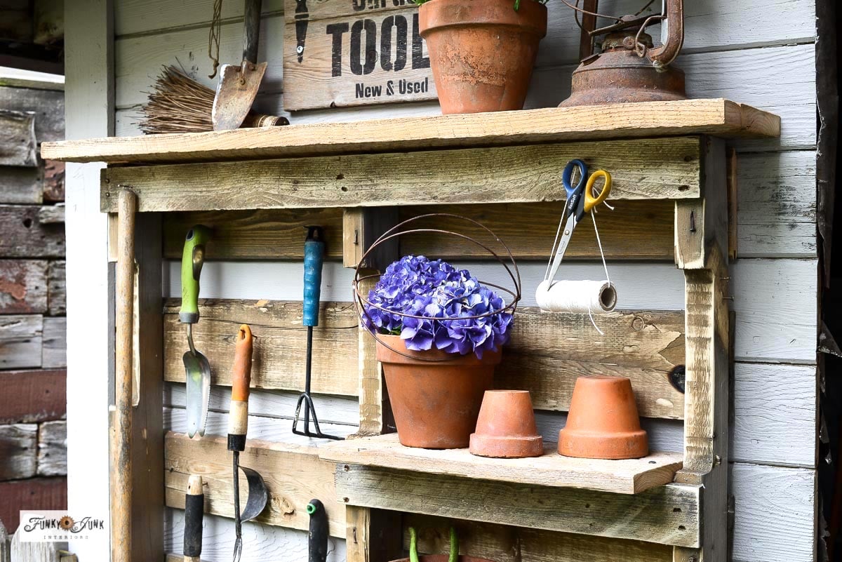 DIY pallet yard tool organizer with shelves and hooks