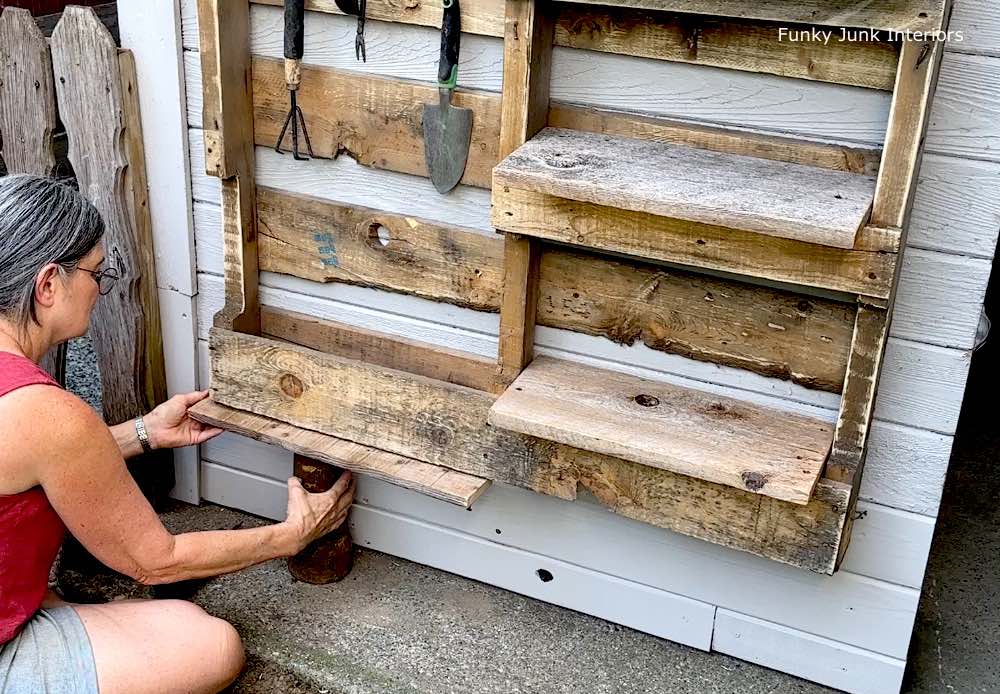 Install a board along the bottom of the pallet to create a shelf