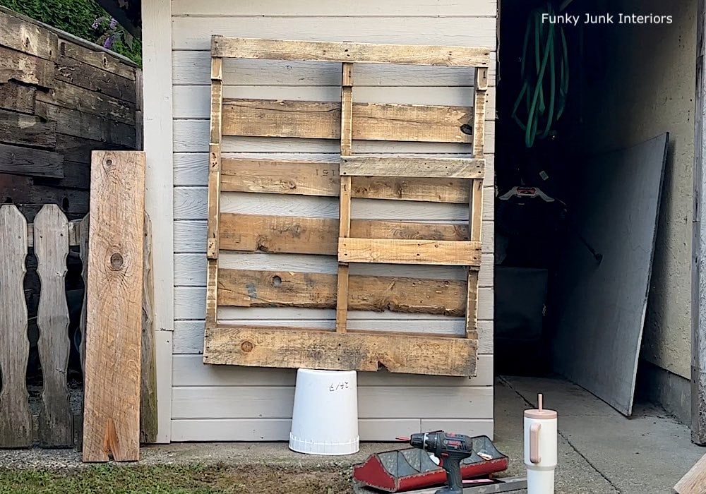 mounting a pallet on a garden shed to make a pallet yard tool organizer