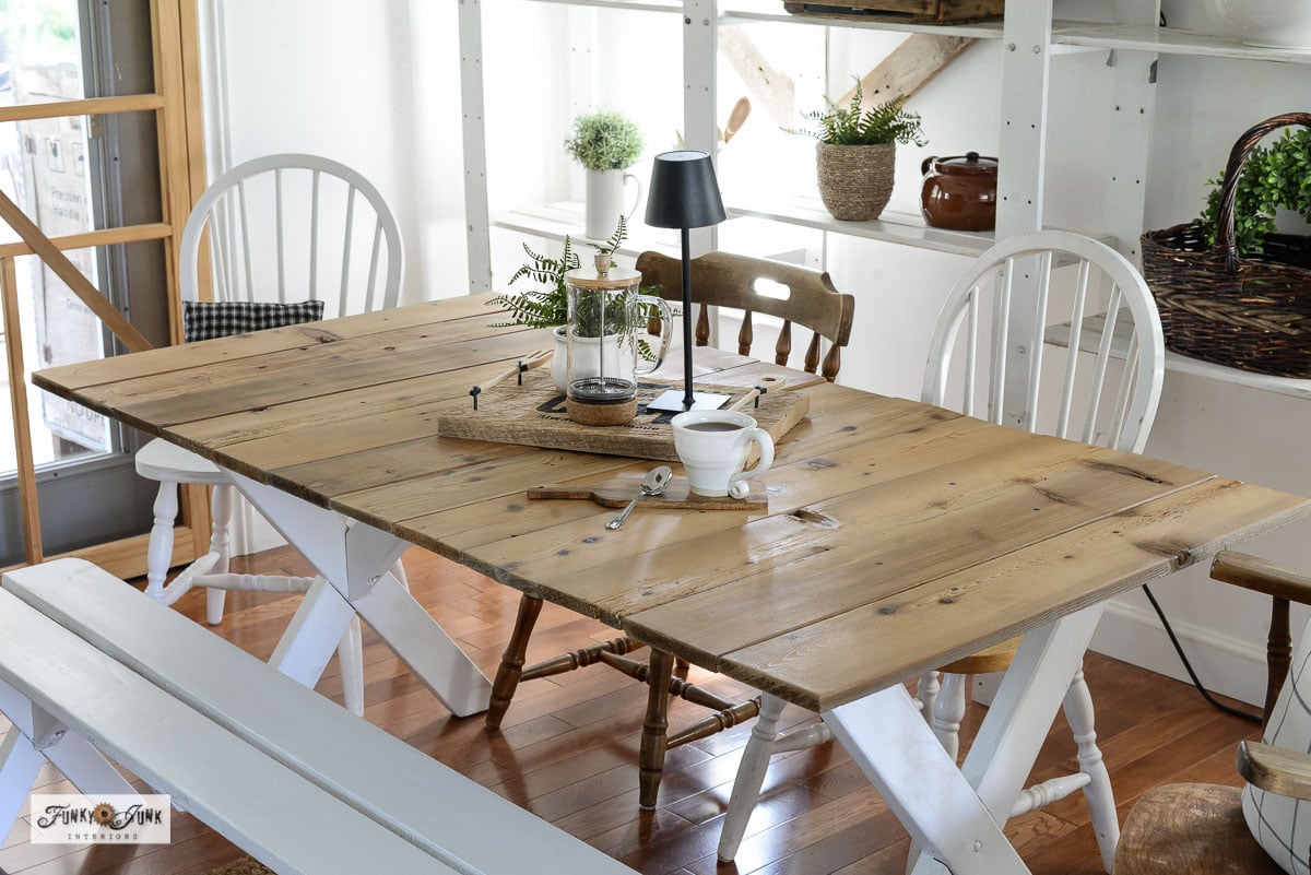 farmhouse dining table made from a picnic table painted white with a reclaimed wood top