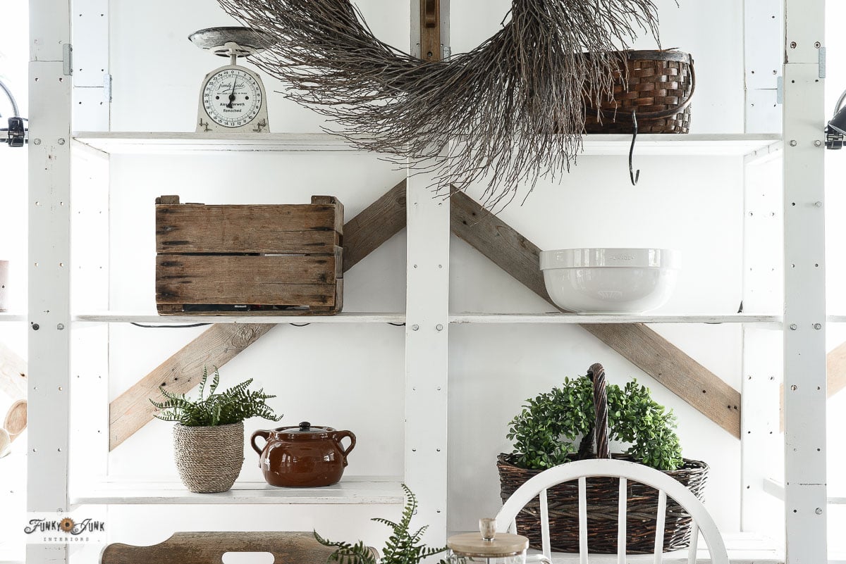 staging shelves with kitchen items and plants for the farmhouse dining table area