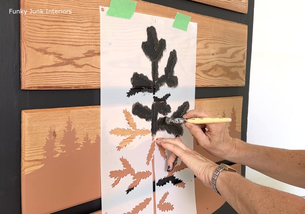 stenciling a taller forest tree seedling on landscape painted furniture