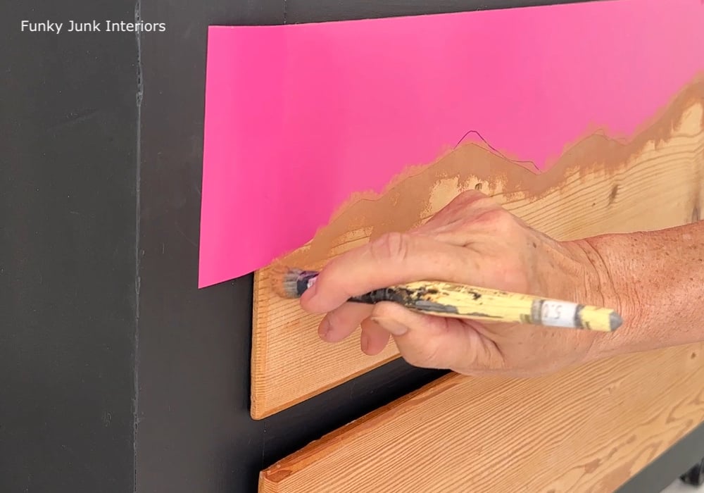 stenciling along a landscape mask on a painted dresser