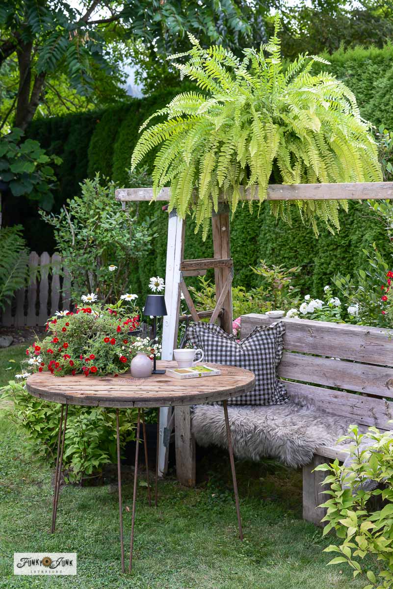 Transform your outdoor space effortlessly with a charming DIY arbor crafted from ladders, paired perfectly with a rustic cable reel table and wooden bench for rustic charm outdoor seating!