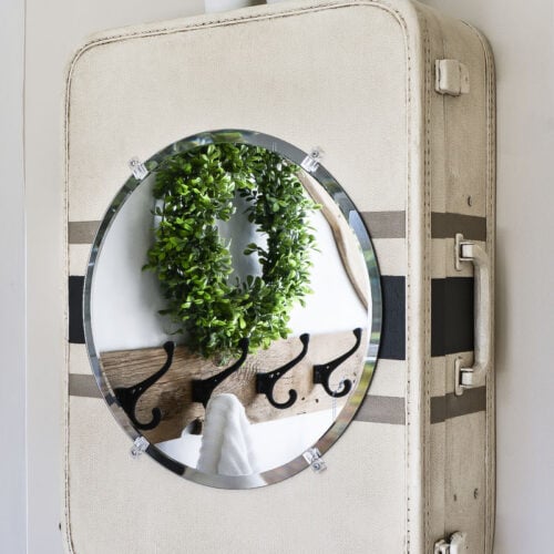 round mirror on a vintage suitcase medicine cabinet