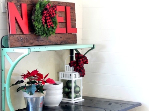 Rustic-Christmas-pallet-noel-wreath-sign-on-antique-stove-with-ornaments-in-lantern-Knick-of-Time