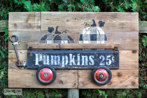 stenciled buffalo check pumpkins in a 3d wagon for fall decor